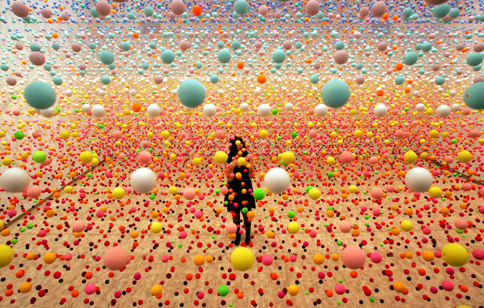 Australian artist Nike Savvas makes final adjustments to her art piece consisting of over 50,000 polystyrene balls at the New South Wales Art Gallery in Sydney August 3, 2006. The sculpture titled "Atomix - Full of Love, Full of Wonder" , vibrates with wind from 10 fans and represents the different "shimmering" colours in a hot, outback landscape. It is part of a sculpture exhibition "Adventures with Form in Space" that will open to the public next week. REUTERS/David Gray