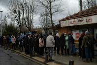 Pour quelques centimes d'euros économisés, les files d'attente s'étirent devant les kiosques du "pain du peuple" subventionné à Istanbul le 18 décembre 2021 (AFP/Yasin AKGUL)