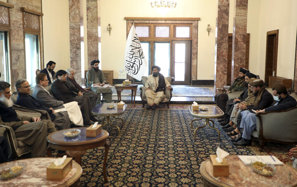 Mullah Abdul Ghani Baradar, the Taliban-appointed deputy prime minister for economic affairs, center, speaks with Pakistan's defense minister, Khawaja Mohammad Asif, left, during a meeting in Kabul, Afghanistan, Wednesday, Feb. 22, 2023. Pakistan's defense minister was in Afghanistan on Wednesday, meeting with officials there in an effort to resolve this week's closure by the Taliban administration of a key border crossing between the two neighboring countries, officials said. (Deputy Prime Minister Minister Office via AP)