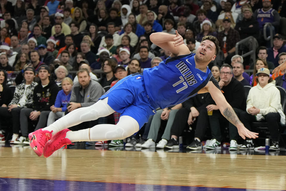 Dallas Mavericks guard Luka Doncic reacts after getting knocked to the ground during the first half of an NBA basketball game against the Phoenix Suns, Monday, Dec. 25, 2023, in Phoenix. (AP Photo/Rick Scuteri)