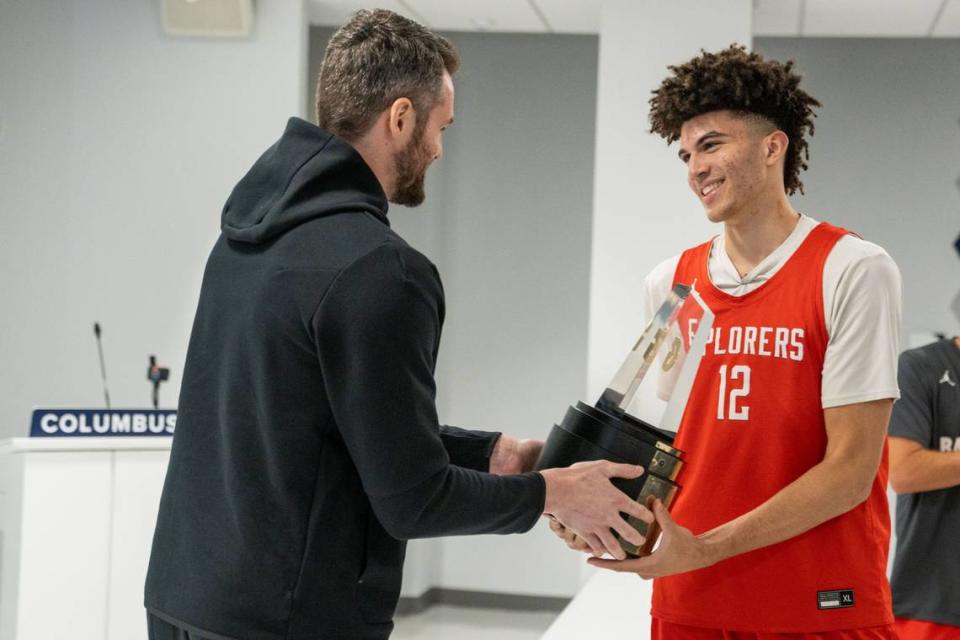 Columbus basketball star Cameron Boozer accepts the Gatorade National Boys Basketball Player of the Year Award trophy from the Miami Heat’s Kevin Love during a ceremony at the school.