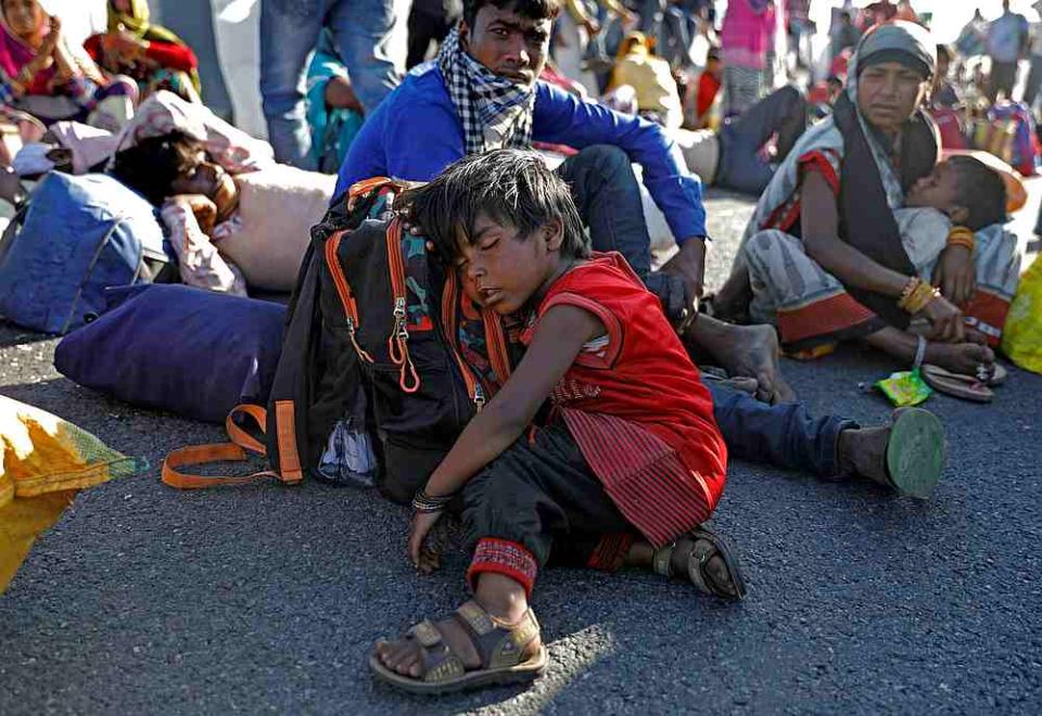 The daughter of a migrant worker sleeps on a highway as her family failed to get a bus to return to their village, during the Covid-19 lockdown in New Delhi, India March 29, 2020. — Reuters pic