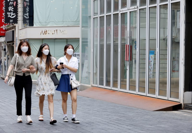 FILE PHOTO: Women wearing masks walk in a shopping district amid the coronavirus disease (COVID-19) pandemic in Seoul