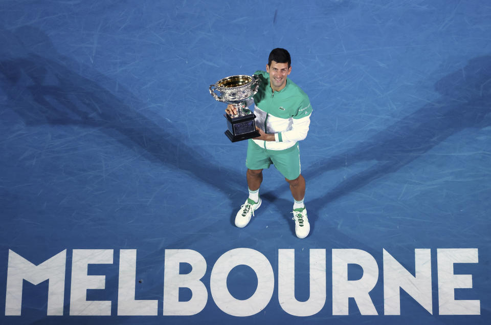 FILE- In this Feb. 21, 2021, file photo, Serbia's Novak Djokovic holds the Norman Brookes Challenge Cup after defeating Russia's Daniil Medvedev in the men's singles final at the Australian Open tennis championship in Melbourne, Australia. Djokovic is 26-0 in Grand Slam matches in 2021, moving him two victories away from being the first man to win all four major tennis championships in one season since Rod Laver in 1969. (AP Photo/Hamish Blair, File)