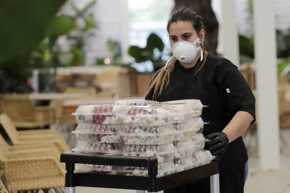 La chef Liset Garcell se prepara para entregar comidas gratis a los afectados por la pandemia del coronavirus en el restaurante Red Rooster de Marcus Samuelsson el lunes 6 de abril de 2020 en el barrio de Overtown de Miami. Samuelsson se asoció con el chef José Andrés y su World Central Kitchen para distribuir alimentos para los necesitados. (Foto AP/Lynne Sladky)