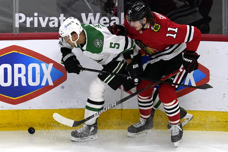 Dallas Stars defenseman Andrej Sekera, left, works for the puck against Chicago Blackhawks center Adam Gaudette during the second period of an NHL hockey game in Chicago, Sunday, May 9, 2021. (AP Photo/Nam Y. Huh)