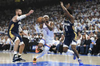 Oklahoma City Thunder guard Shai Gilgeous-Alexander (2) drives past New Orleans Pelicans center Jonas Valanciunas, left, and forward Herbert Jones (5) in the first half of Game 1 of an NBA basketball first-round playoff series, Sunday, April 21, 2024, in Oklahoma City. (AP Photo/Kyle Phillips)