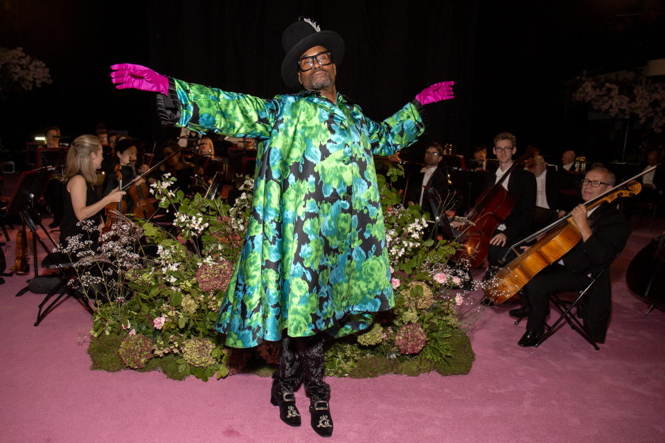 The entertainer had a theatrical look at Richard Quinn's SS20 show wearing a blue and white printed gown with hot pink gloves and a black hat [Photo: Getty Images]