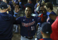 Minnesota Twins Jorge Polanco (11) is greeted in the dugout after scoring on a hit in the third inning against the Texas Rangers at a baseball game Sunday, June 20, 2021, in Arlington, Texas. (AP Photo/Richard W. Rodriguez)