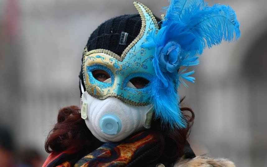 A Venice Carnival participant wears a mask in response to the coronavirus threat - MEGA