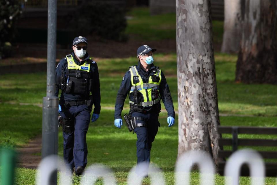 Police patrol the grounds of a public housing estate which is undergoing a forced lockdown in Melbourne. 