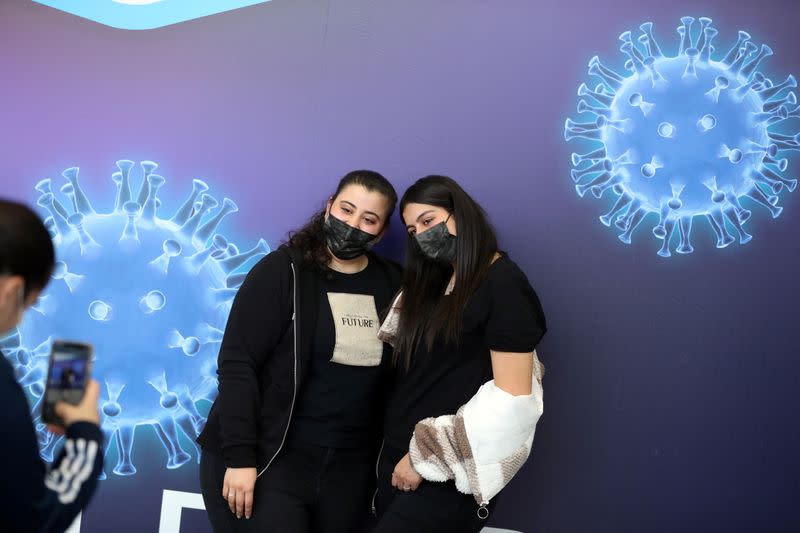 Teen girls have their picture taken in a temporary Clalit healthcare maintenance organisation (HMO) vaccination centre in Jerusalem