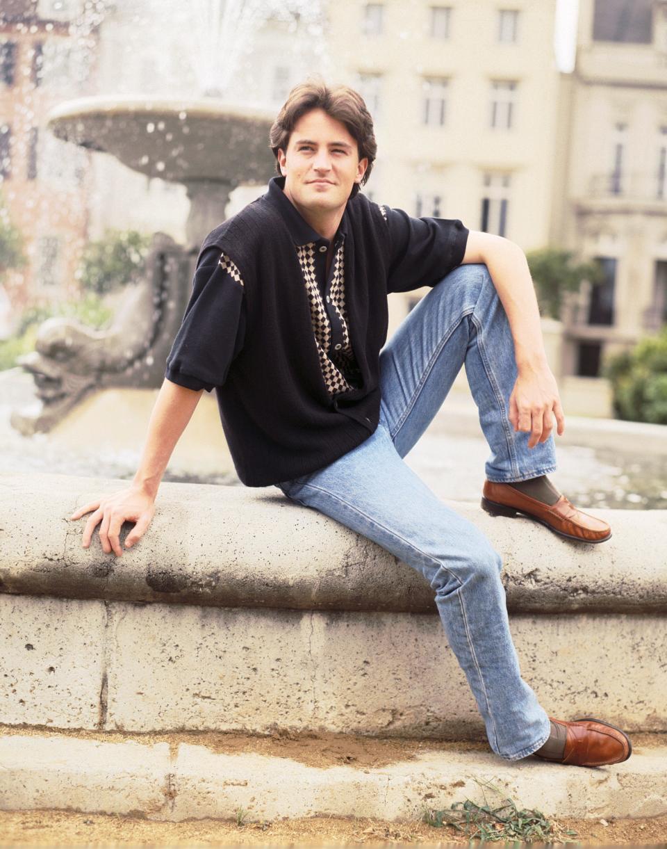 Matthew Perry sitting on a fountain