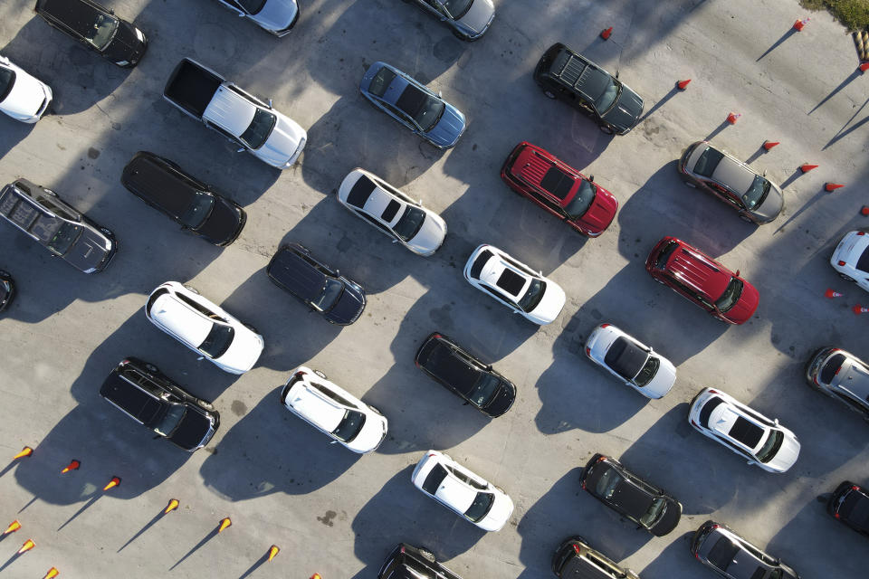 FILE - In this photo taken by drone, cars wait in long lines at a drive-up coronavirus testing center at the Tropical Park, Wednesday, Dec. 29, 2021, in Miami. The official global death toll from COVID-19 is on the verge of eclipsing 6 million — underscoring that the pandemic, now in its third year, is far from over. (AP Photo/Rebecca Blackwell, File)
