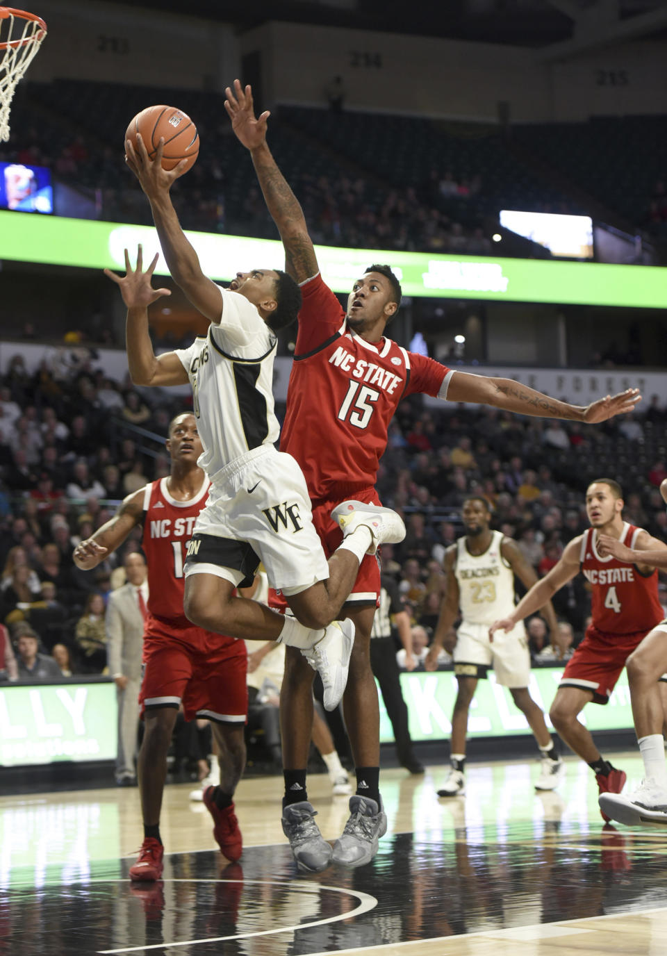 Wake Forest's Brandon Childress is fouled by N.C. State's Manny Bates as he sinks a layup in the first half of an NCAA men's basketball game, Saturday, Dec. 7, 2019 at Joel Coliseum in Winston-Salem, N.C. (Walt Unks/Winston-Salem Journal via AP)