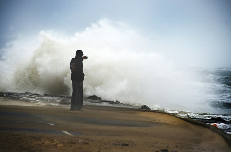 Tourist watch as waves batter the beach in Ocean City, Maryland, on October 3, 2015