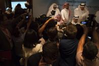 Saudi Energy Minister Prince Abdulaziz bin Salman, seated right, and OPEC Secretary-General Mohammed Barkindo, seated left, speak to journalists after a news conference that followed an OPEC meeting in Abu Dhabi, United Arab Emirates, Thursday, Sept. 12, 2019. OPEC's Joint Ministerial Monitoring Committee met Thursday in Abu Dhabi as estimates of lowered crude oil demand in 2020 have the cartel considering additional production cuts. Before the meeting started, Prince Abdulaziz again called for "cohesiveness" in OPEC. (AP Photo/Jon Gambrell)