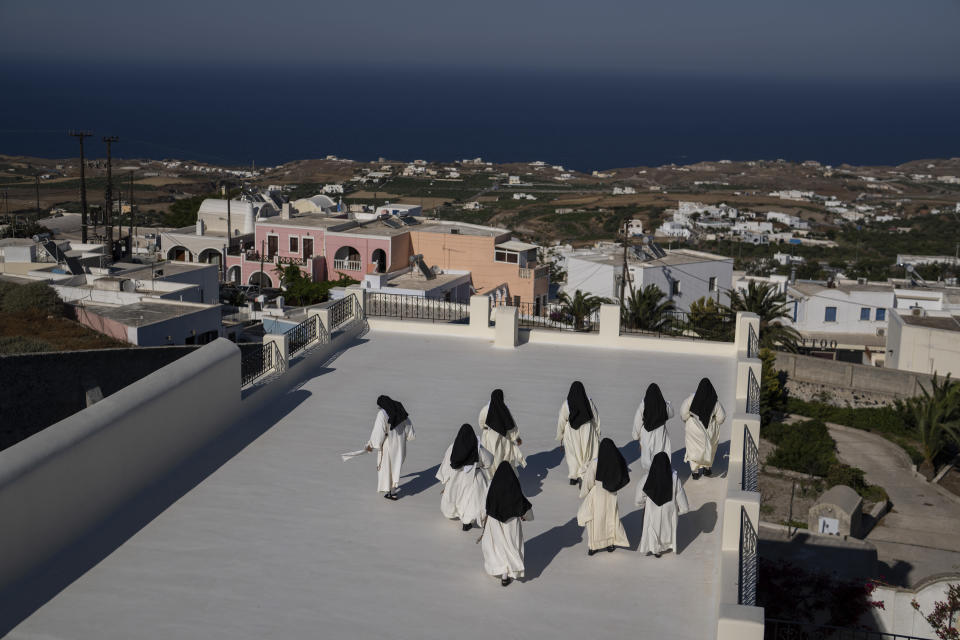 Monjas de clausura fotografiadas en una terraza del Montasterio Católico de Santa Catalina en la isla griega de Santorini el 14 de junio del 2022. Es uno de los pocos contactos que tienen con el mundo exterior. (AP Photo/Petros Giannakouris)