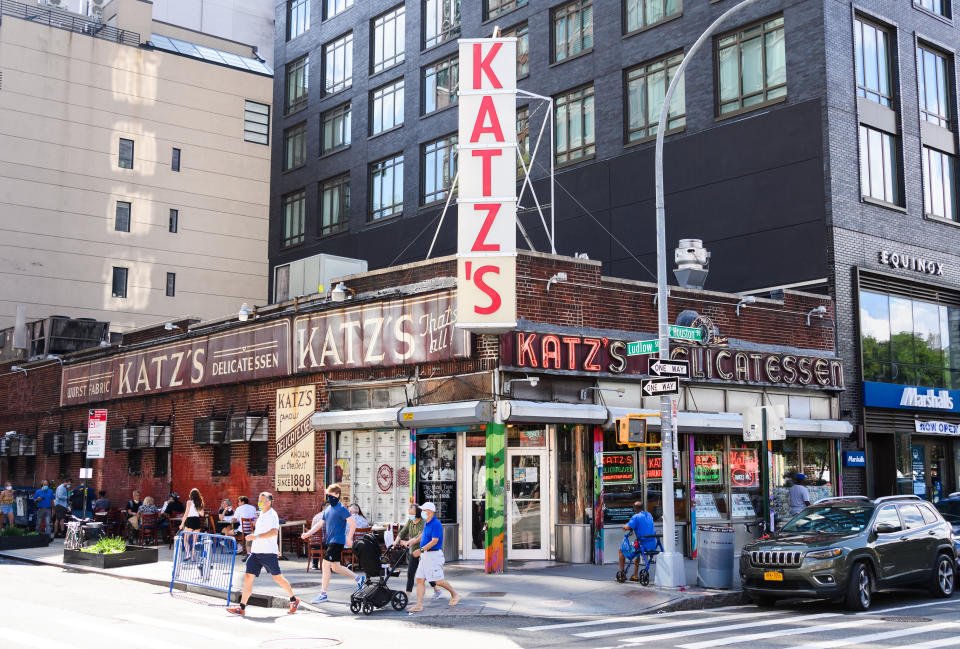 NEW YORK, NEW YORK - AUGUST 18: People wear protective face masks outside Katz's Delicatessen on the Lower East Side as the city continues Phase 4 of re-opening following restrictions imposed to slow the spread of coronavirus on August 18, 2020 in New York City. The fourth phase allows outdoor arts and entertainment, sporting events without fans and media production. (Photo by Noam Galai/Getty Images)