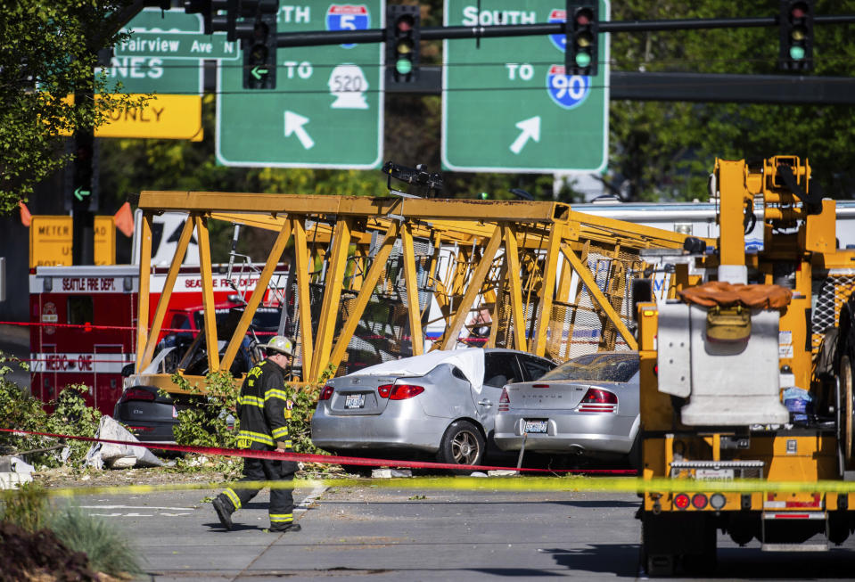 FILE - In this April 27, 2019, file photo, emergency crews work the scene of a construction crane collapse near near Interstate 5 in Seattle, where four were killed. Washington state's Department of Labor and Industries released the results of its investigation into the collapse Thursday, Oct. 17, 2019. It found, as experts have long suspected, that the crane toppled because workers who were disassembling it had prematurely removed pins securing the sections of the crane's mast. (Joshua Bessex/The News Tribune via AP, File)