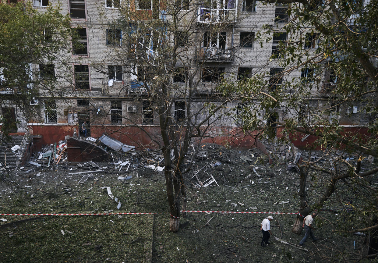 Local residents walk past a damaged building after a rocket attack early Wednesday morning, in Kramatorsk, eastern Ukraine, Wednesday, Aug. 31, 2022. (AP Photo/Kostiantyn Liberov)