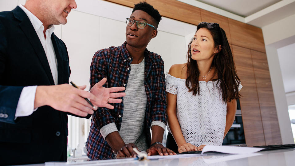 couple having consultation with a real estate agent inside a new home.