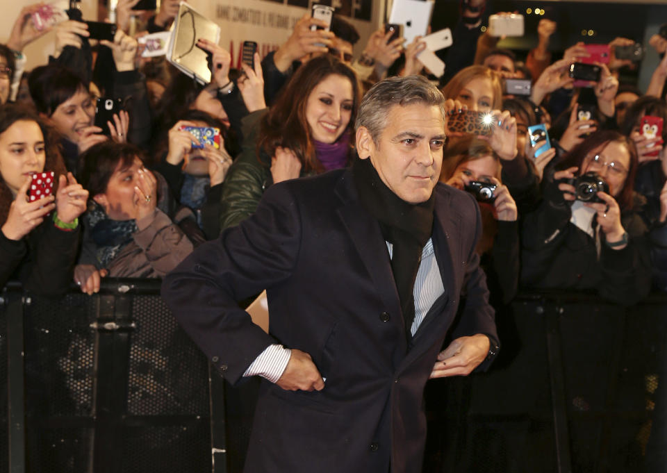 American actor George Clooney poses for photographers on the red carpet for the screening of the movie "Monuments Men ", in Pioltello, near Milan, Italy, Monday, Feb. 10, 2014. (AP Photo/Antonio Calanni)