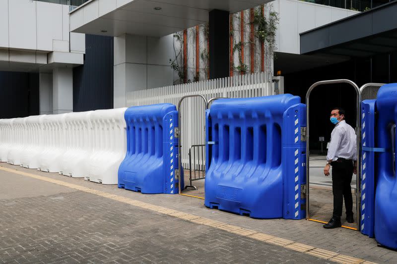 A man wearing a protective mask stands next to a barricade outside Legislative Council Complex as a second reading of a controversial national anthem law takes place in Hong Kong