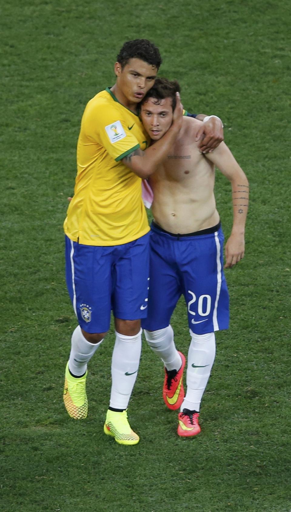 Brazil's Thiago Silva and Bernard leave the pitch after their 2014 World Cup opening match against Croatia at the Corinthians arena in Sao Paulo