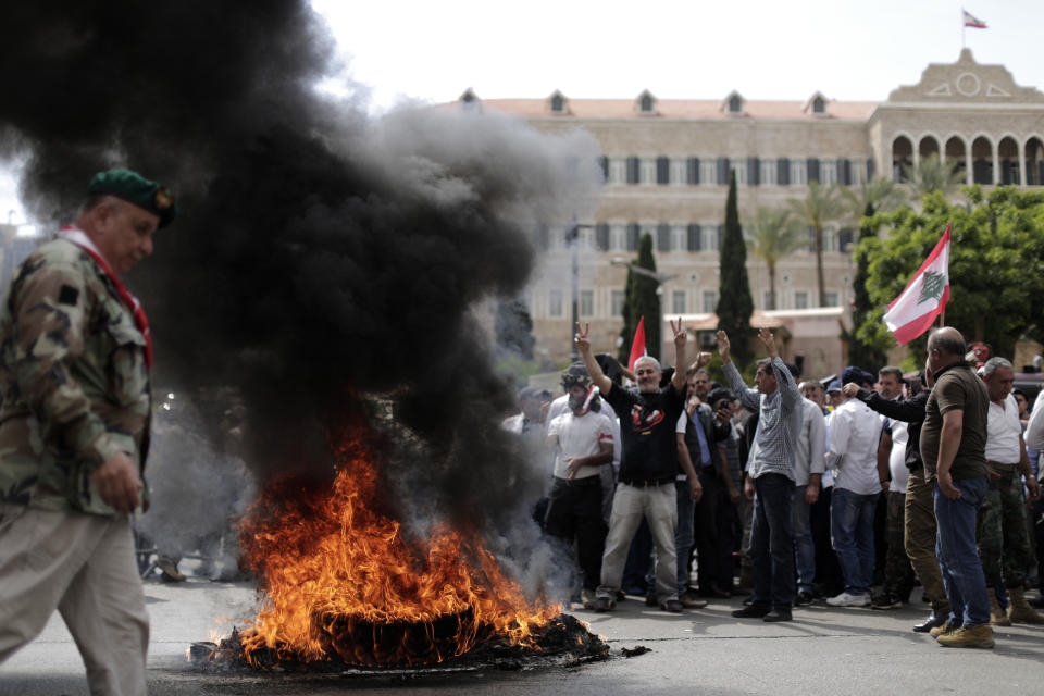 Lebanese retired soldiers burn tires as they protest in front of the government building during a cabinet meeting to discuss an austerity budget, in Beirut, Lebanon, Friday, May 10, 2019. Dozens of Lebanese military and security veterans burned tires and shouted angrily outside government offices on Friday, their second protest in less than two weeks amid fears a proposed austerity budget may affect their pensions and benefits. (AP Photo/Hassan Ammar)