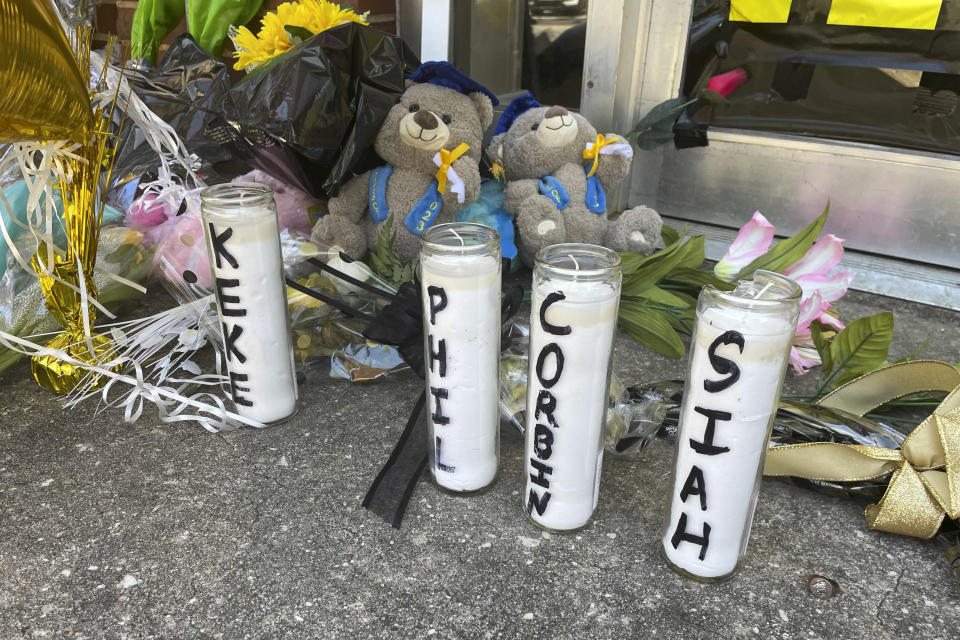 Candles with the names of the four young people killed in a shooting and teddy bears dressed in graduation caps sit outside the Mahogany Masterpiece dance studio on Wednesday, April 19, 2023, in Dadeville, Ala. Two teenagers have been arrested and charged with murder in connection with the shooting at a Sweet Sixteen birthday party, Alabama investigators announced Wednesday. (AP Photo/Kimberly Chandler)