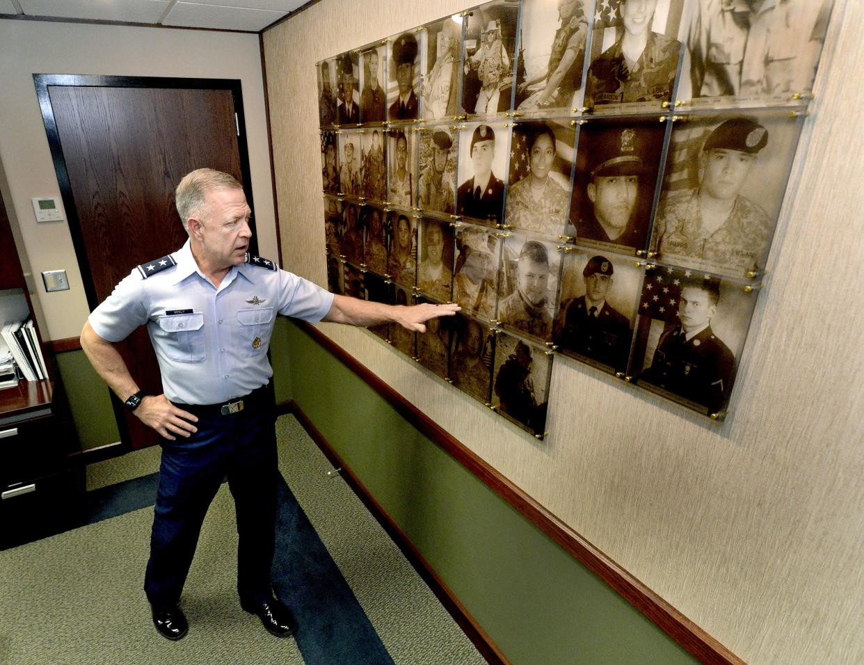 Major General Richard Neely points out photos of the 34 fallen Illinois National Guard personnel Tuesday, April 2, 2024, during an interview about his upcoming retirement.