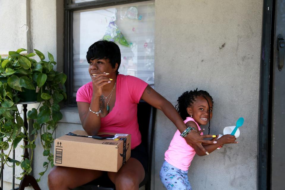 Regina Mumford chats on the porch of her Yamacraw Village apartment. “Crime is bad, maintenance is jacked up. I’ve got a (handrail on my) staircase in my hallway that fell apart two weeks ago and nobody still hasn’t come to fix it,” said Mumford, who said she also faces issues with her plumbing and mold.