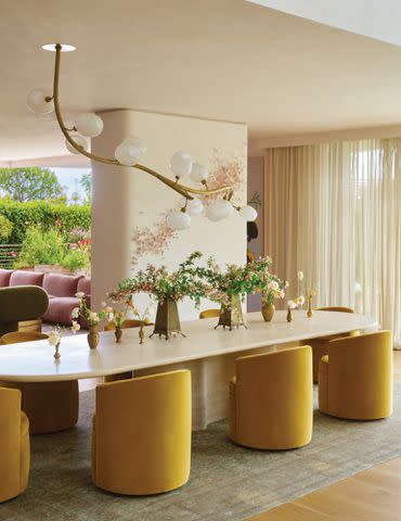 <p>Yoshihiro Makino/Architectural Digest</p> A Jeff Zimmerman light branch hangs above the couple's Joseph Dirand rounded dining table.