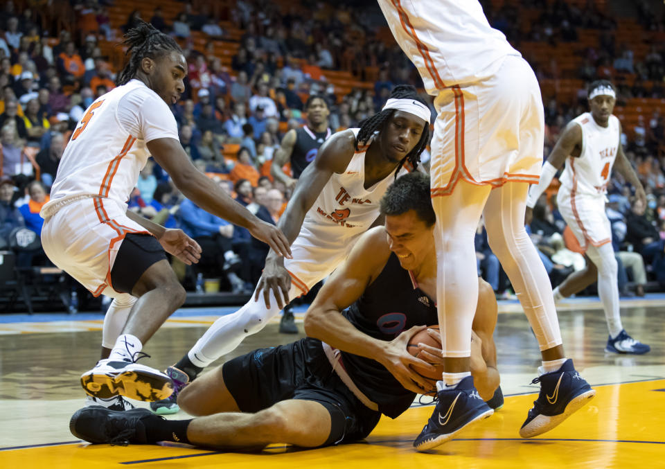 Florida Atlantic center Vladislav Goldin (50) shields the ball after grabbing a rebound against UTEP guard Shamar Givance, left, and guard Tae Hardy, back, during the first half of an NCAA college basketball game Saturday, Jan. 21, 2023, in El Paso, Texas. (AP Photo/Andrés Leighton)