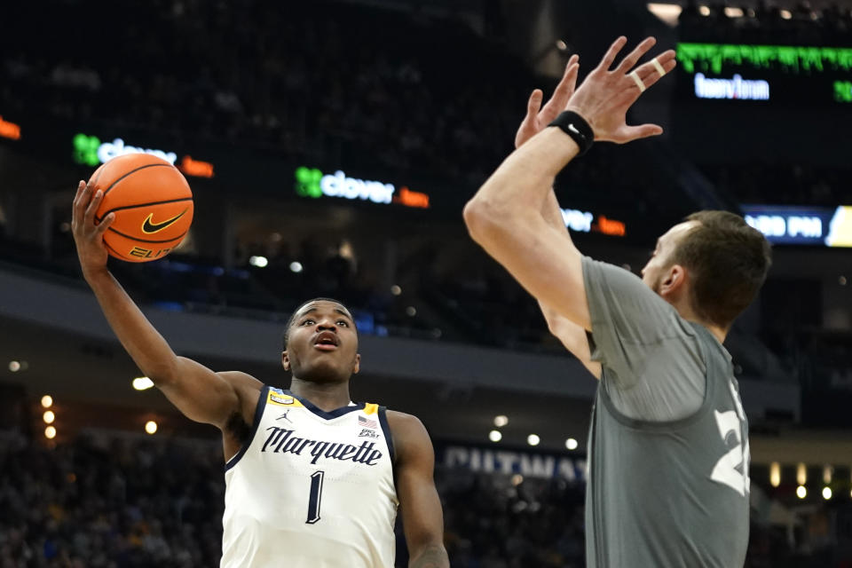 Marquette's Kam Jones (1) shoots against Xavier's Jack Nunge during the first half of an NCAA college basketball game Wednesday, Feb. 15, 2023, in Milwaukee. (AP Photo/Aaron Gash)