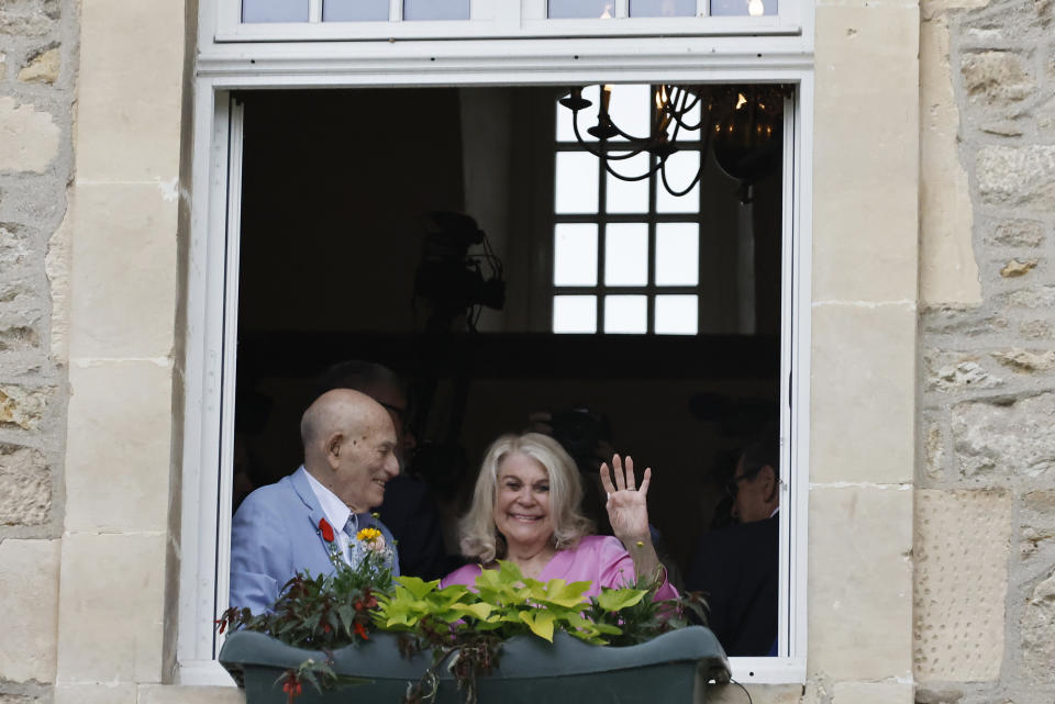 US WWII veteran Harold Terens, 100, left, and Jeanne Swerlin, 96, smile from a window after celebrating their wedding at the town hall of Carentan-les-Marais, in Normandy, northwestern France, on Saturday, June 8, 2024. Together, the collective age of the bride and groom was nearly 200. But Terens and his sweetheart Jeanne Swerlin proved that love is eternal as they tied the knot Saturday inland of the D-Day beaches in Normandy, France. (AP Photo/Jeremias Gonzalez)