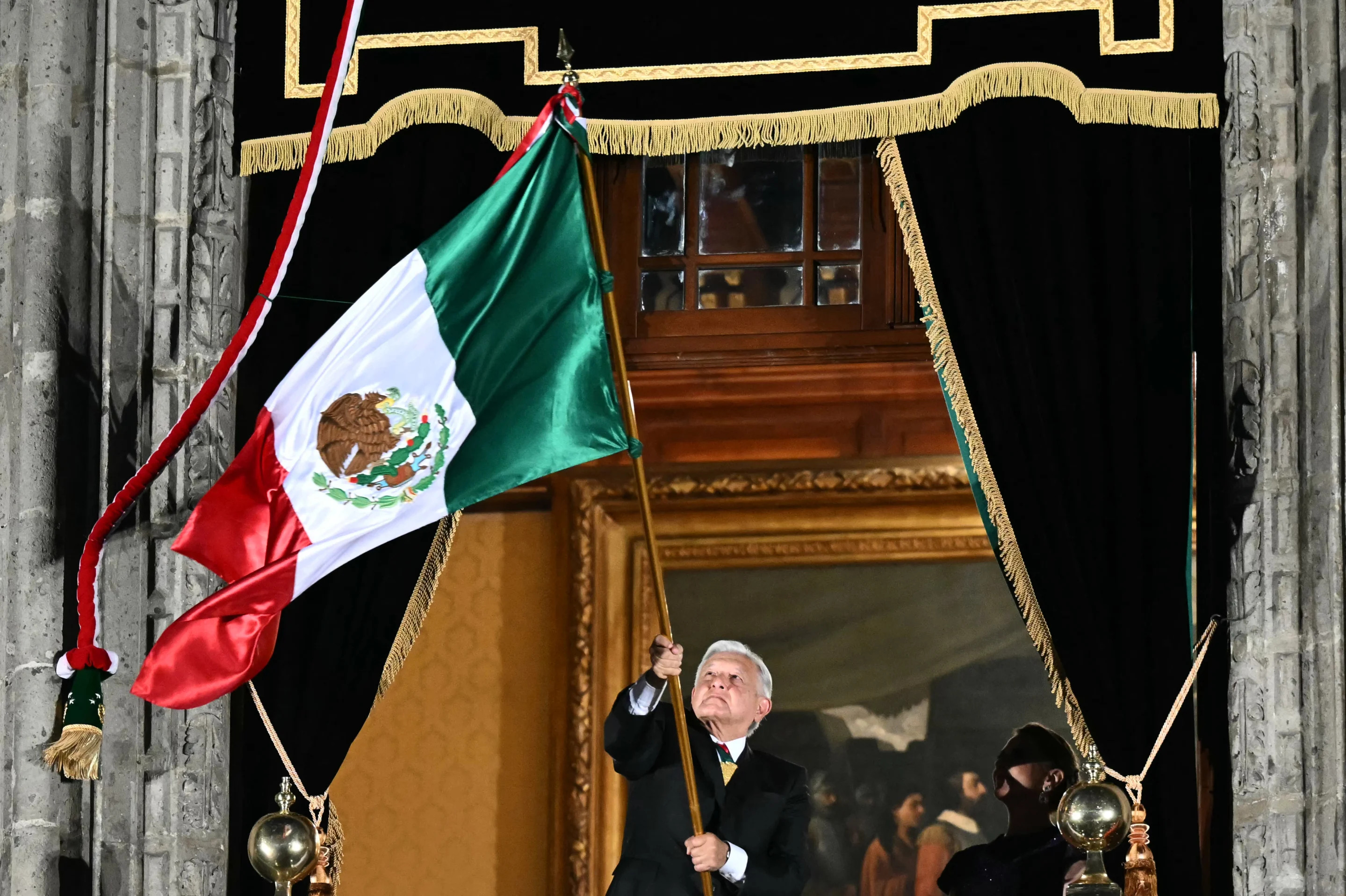 El presidente Andrés Manuel López Obrador alza la bandera de México y se despide de sus partidarios durante su último acto público como presidente de México en la ceremonia del 'Grito de Independencia'. (Photo by CARL DE SOUZA/AFP via Getty Images)