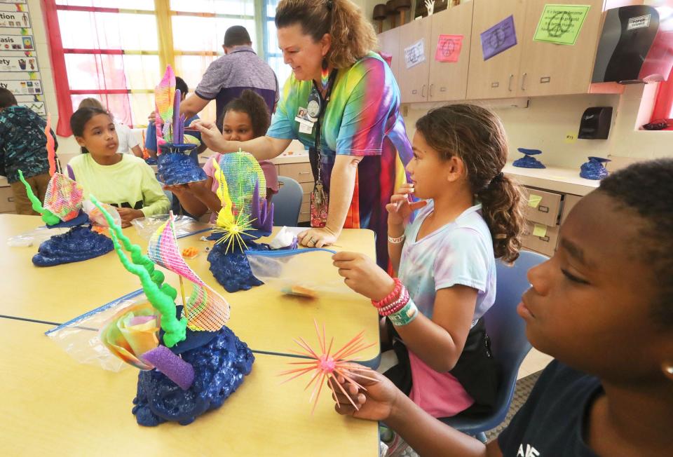 Teacher Dorothy Featherston helps a table of fourth-graders build a coral reef art project, Tuesday, Feb. 28, 2023, at South Daytona Elementary School.