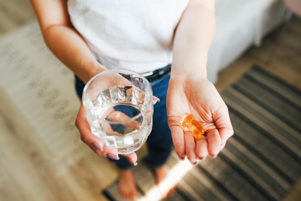 You might want to load up on these six vitamins to stay healthy this winter. (Photo via Getty Images) The girl holds vitamins and a glass of water in her hand. Morning rituals. Water. Glass of water. Water balance in the body. Vitamins. Vitamins and dietary supplements.