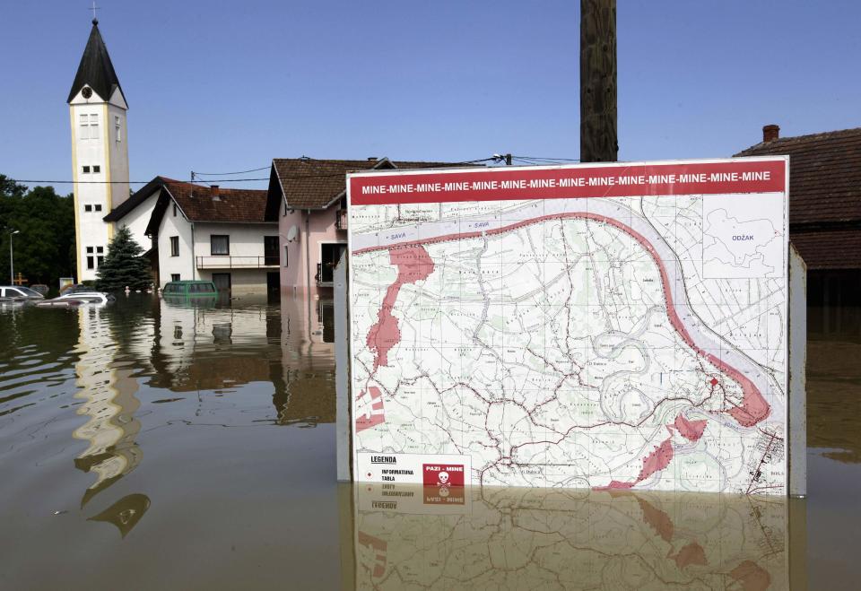 A map showing a land mine field is seen in the water during heavy floods in the village of Prud