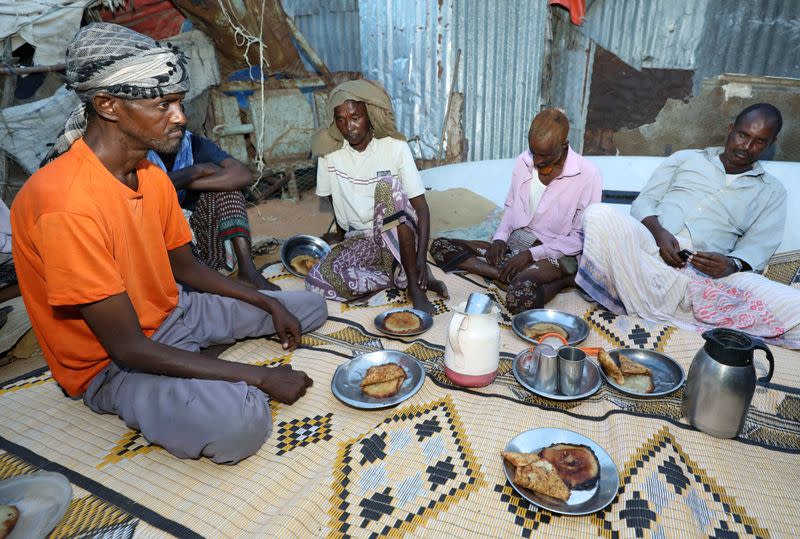 Internally displaced Somalis eat their Iftar meal during the month of Ramadan at the Shabelle makeshift camp in Hodan district of Mogadishu