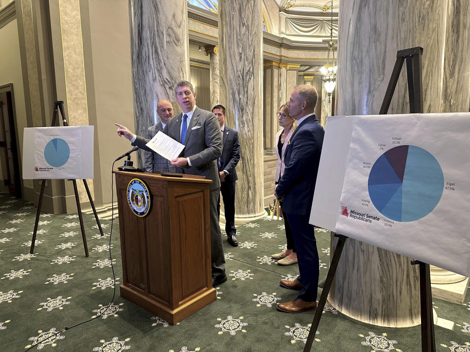 Missouri state Sen. Bill Eigel points to a poster-sized chart prepared by Republican Senate leadership showing how much time during this year's Senate sessions has been consumed by members of the Freedom Caucus on Thursday, Jan. 25, 2024, at the state Capitol in Jefferson City, Mo. Eigel, a Republican, is a Freedom Caucus member who has frequently spoken on the Senate floor against the party's leadership. (AP Photo/David A. Lieb)