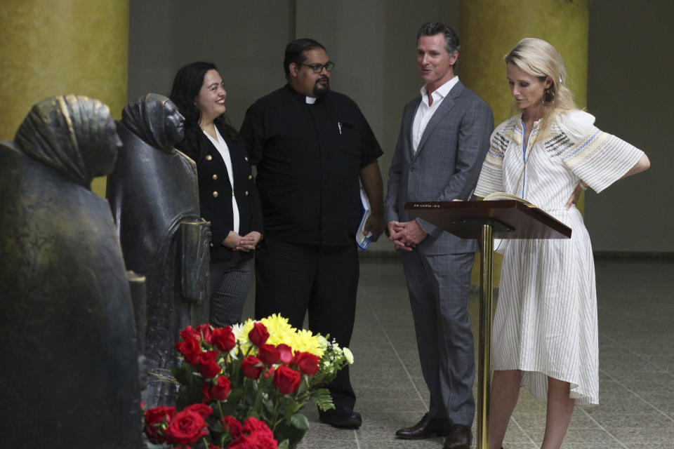 California Gov. Gavin Newsom, third from left, and his wife Jennifer Siebel Newsom visit the tomb of Archbishop Oscar Romero at Metropolitan Cathedral in San Salvador, El Salvador, Sunday, April 7, 2019. Father Francisco Villalobos, second from left, and California state Assemblywoman Wendy Carrillo, left are also seen. Newsom visited the tomb of Archbishop Romero, the Salvadoran priest assassinated in 1980 due to his advocacy for human rights and the poor. (AP Photo/Salvador Melendez, Pool)