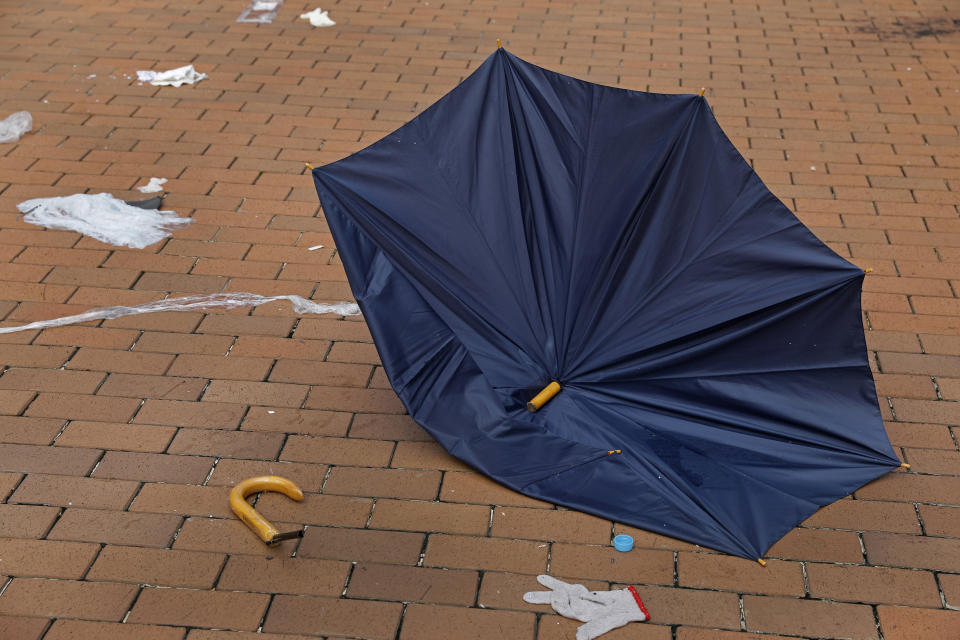 In this Friday, June 14, 2019, photo, a broken umbrella left in the aftermath of Wednesday's violent protest against proposed amendments to an extradition law is seen in Hong Kong. Umbrellas became a symbol of protest in Hong Kong in 2014 after demonstrators used them to shield themselves from both police pepper spray and a hot sun. Five years later, umbrellas were out in force again on Wednesday as thousands of protesters faced off with police outside the legislature. (AP Photo/Vincent Yu)