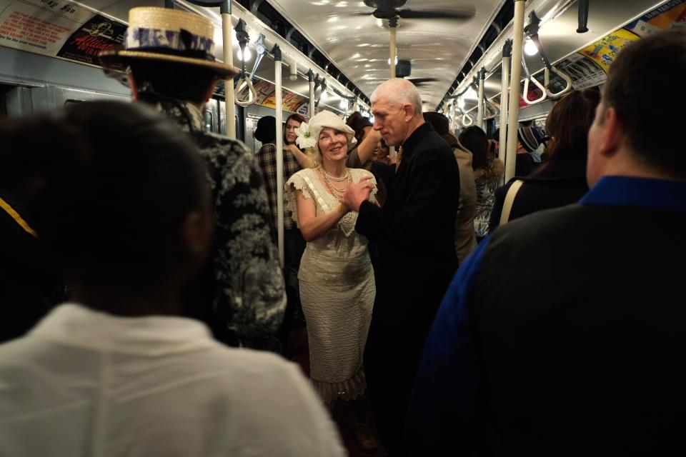 NEW YORK, NY - DECEMBER 16: People dance in a vintage New York City subway car as it moves along the M line on December 16, 2012 in New York City. The New York Metropolitan Transportation Authority (MTA) runs vintage subway trains from the 1930's-1970's each Sunday along the M train route from Manhattan to Queens through the first of the year. (Photo by Preston Rescigno/Getty Images)