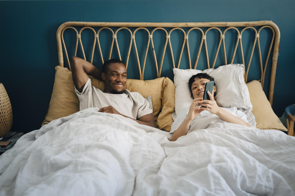 couple on phone in bed