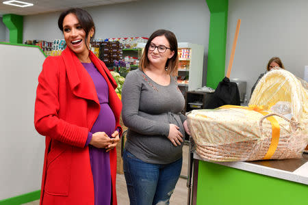 FILE PHOTO: Meghan, Duchess of Sussex presents Angela Midgley with a Moses basket at "Number 7", a "Feeding Birkenhead" citizens supermarket and community cafe, in Birkenhead, Britain January 14, 2019. Anthony Devlin/Pool via REUTERS/File Photo