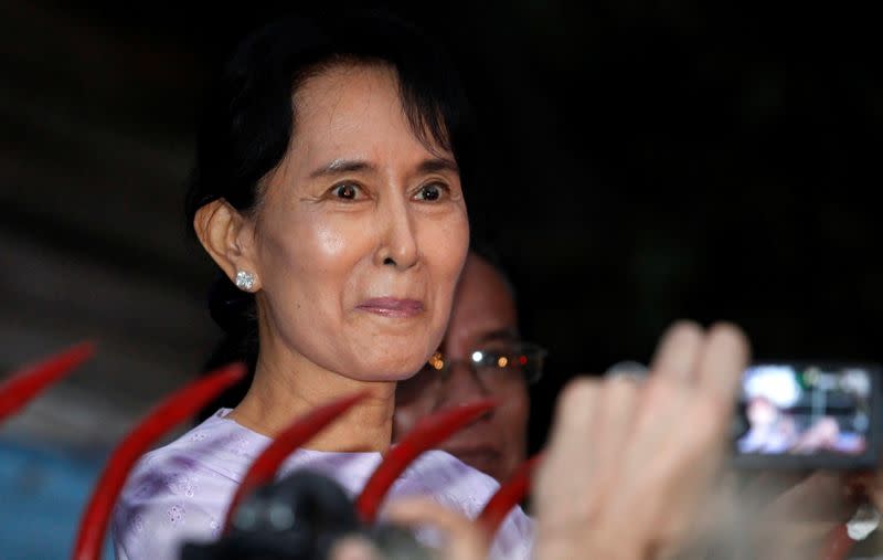 FILE PHOTO: Nobel Peace Prize Laureate Aung San Suu Kyi reacts while speaking with supporters outside her home, where she was placed under house arrest for seven years, in Yangon