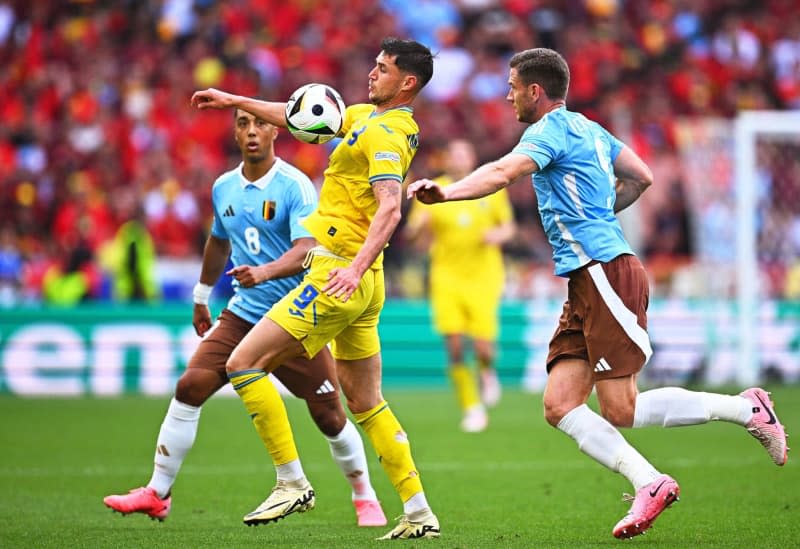 Roman Yaremchuk, jucătorul Ucrainei, se confruntă cu Youri Tielemans (stânga) și Jan Vertonghen, jucătorii Belgiei, în timpul meciului Euro 2024 din Grupa E dintre Ucraina și Belgia de pe Arena Stuttgart.  Tom Wheeler/dpa